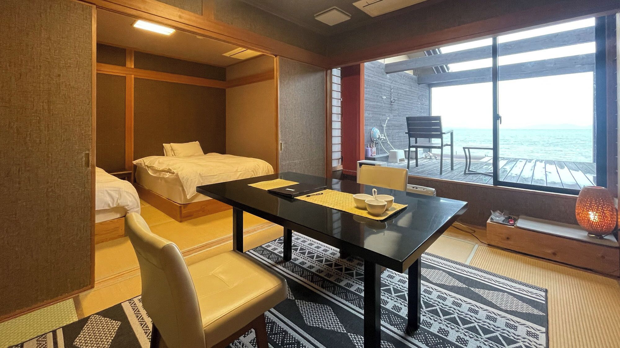 Habitación de hotel con cama, escritorio, silla y vista al mar.