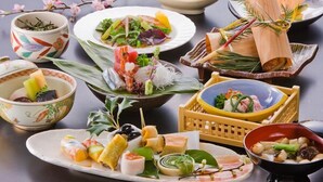 A variety of Japanese dishes arranged on a table, including sushi, sashimi, and other delicacies, with a branch of cherry blossoms in the background. - Worifushi no Yado Shougetsu (Koriyama)