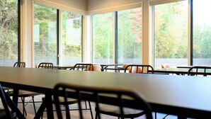 A conference room with large windows, a long table, and chairs. - Ties Verde Hotel (Okuma)