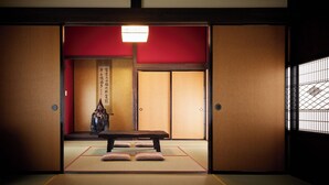 A traditional Japanese room with tatami flooring, a low table, and sliding doors. - Totonoi Kominka Villa Igashima (Aga)
