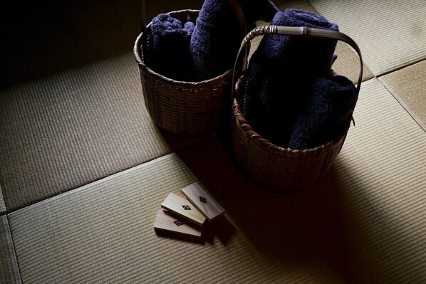 Two wicker baskets with dark blue towels on a textured floor.