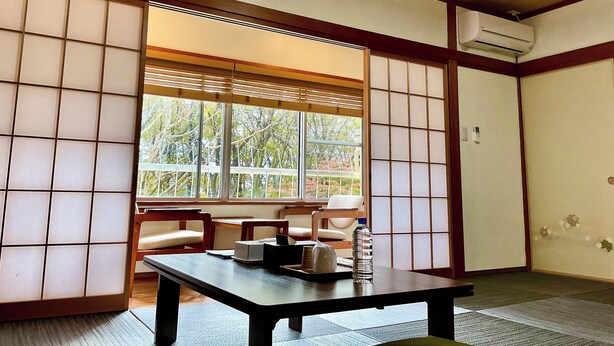 A traditional Japanese room with tatami flooring, a low table, and sliding doors. - Ducale Resort Hotel Nasu Kanronoyu (Nasu)