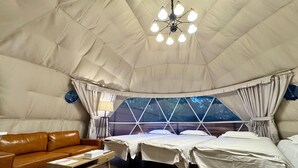 A tented accommodation with a bed, a sofa, a lamp, and a trash bin. - Ducale Resort Hotel Nasu Kanronoyu (Nasu)