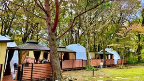 A row of yurts with a covered patio area, surrounded by trees. - Ducale Resort Hotel Nasu Kanronoyu (Nasu)