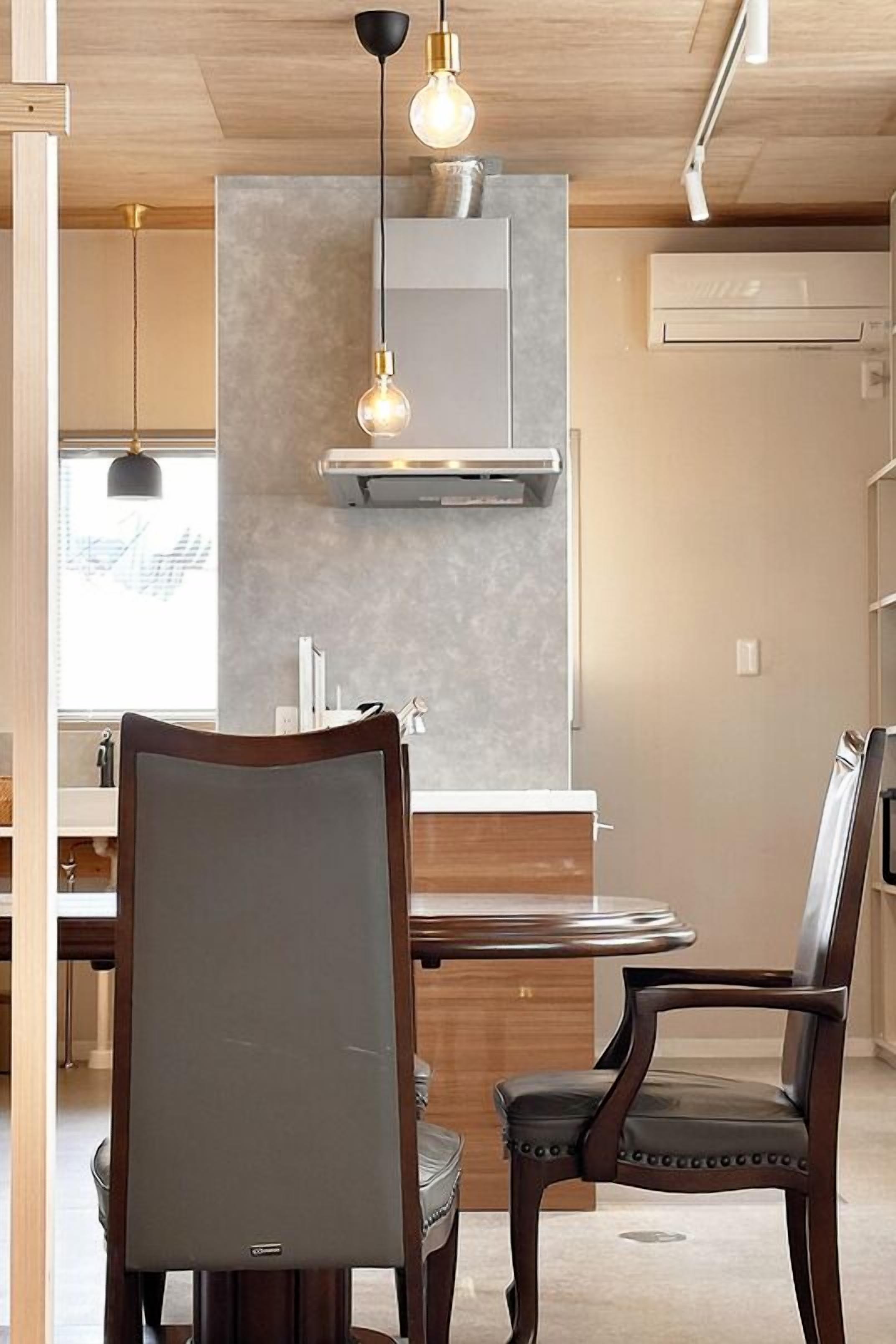 A modern kitchen with a central island, pendant lighting, and a built-in stove.