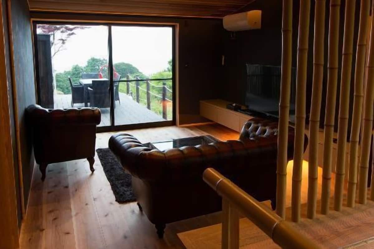 Un salon moderne avec un plafond en bois, un grand téléviseur et une vue sur un balcon.