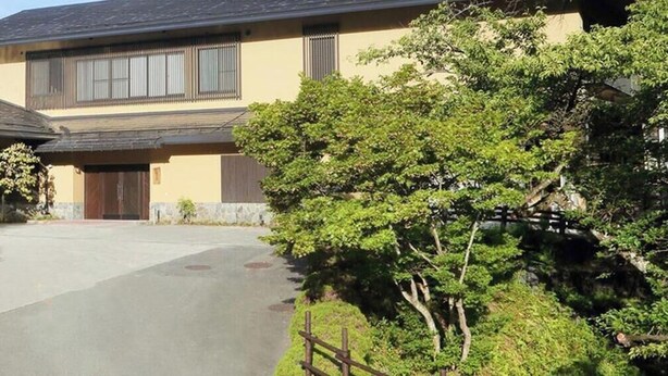 A two-story building with a flat roof, a front entrance, and a paved driveway leading to the entrance. - Oyado Mori no Ne (Kaminoyama)