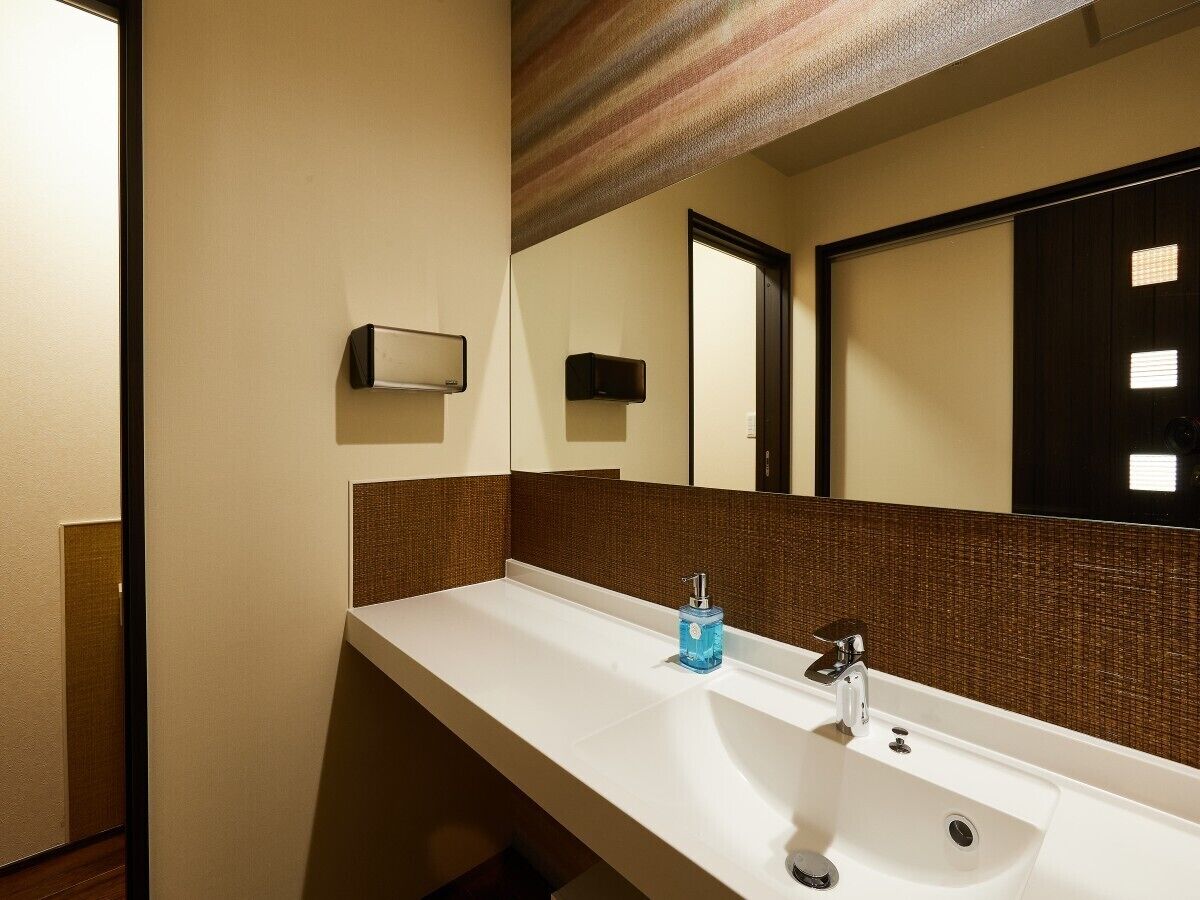 Une salle de bain avec un lavabo blanc, un miroir et un porte-serviettes.