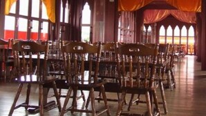 A spacious hall with wooden chairs arranged in rows, large windows with draped curtains, and a ceiling fan. - Shuzenji Tokinosumika Hotel Olive Tree/ Hyakuwarai (Izunokuni)