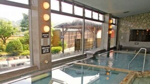 An indoor swimming pool with clear glass walls, a tiled floor, and a wooden deck area. - Shuzenji Tokinosumika Hotel Olive Tree/ Hyakuwarai (Izunokuni)