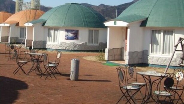 A row of yurts with green roofs, arranged in a courtyard with metal chairs and tables. - Shuzenji Tokinosumika Hotel Olive Tree/ Hyakuwarai (Izunokuni)