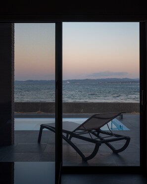 A room with a view of the sea, a pool, and a lounge chair. - Ezra Villa Shirahama (Shirahama)
