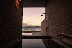 A spa area with a view of the sea, a shower, and a bench. - Ezra Villa Shirahama (Shirahama)