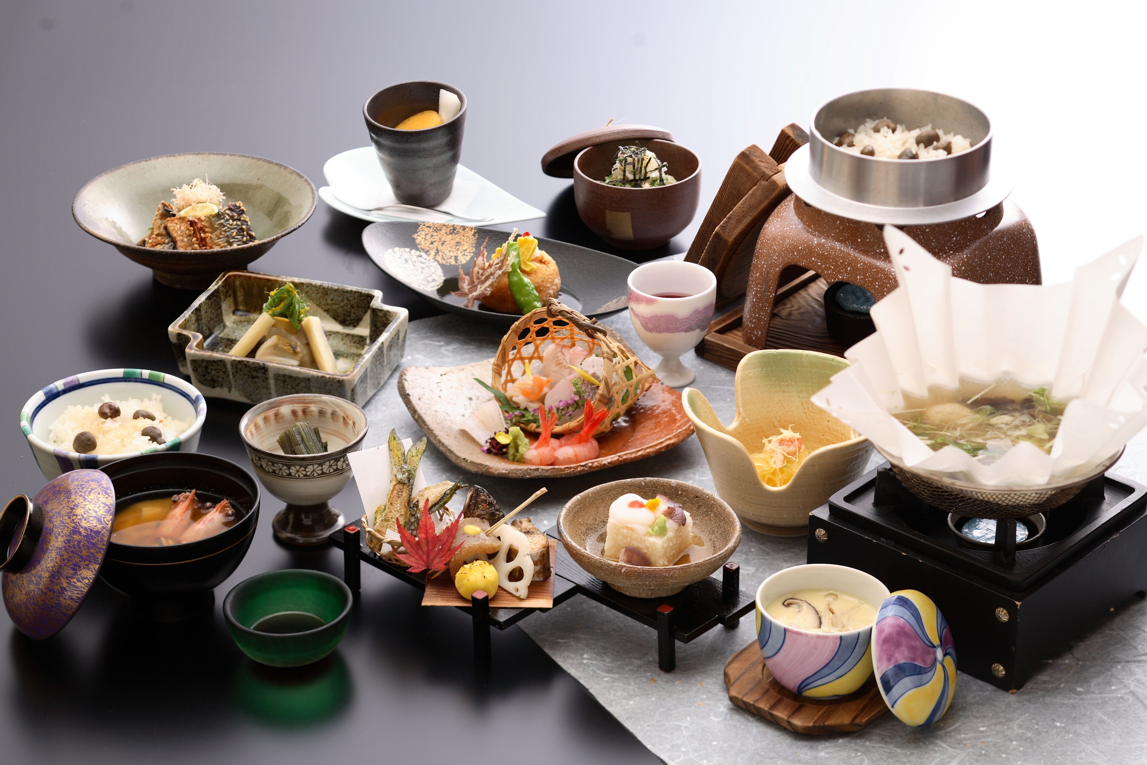 Verschiedene traditionelle japanische Gerichte und Geschirr auf einem Tisch.