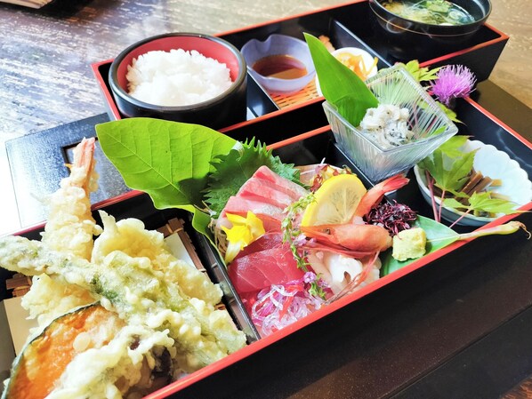 A traditional Japanese meal with various dishes and a small bowl of rice. - Kuwadori Yuttari Village (Joetsu)