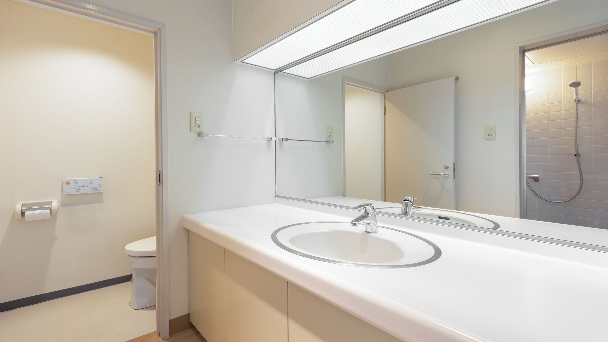 Une salle de bain moderne avec un lavabo blanc, un miroir et une douche.