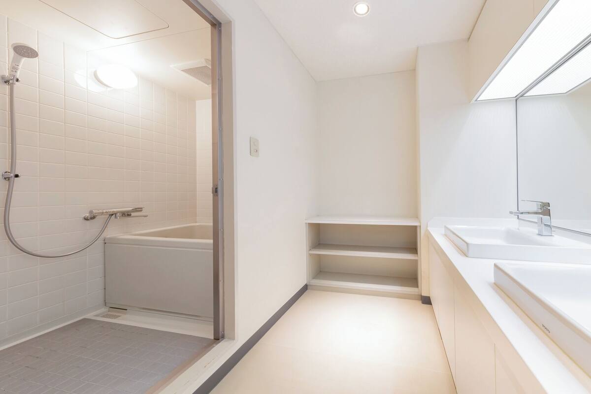 Een moderne badkamer met een inloopdouche, een badkuip en een wastafel met spiegel.
