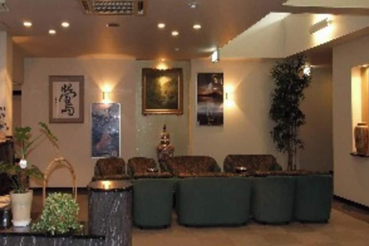 Eine Hotelhalle mit Empfangstresen, Sitzgelegenheiten und Wandbildern.