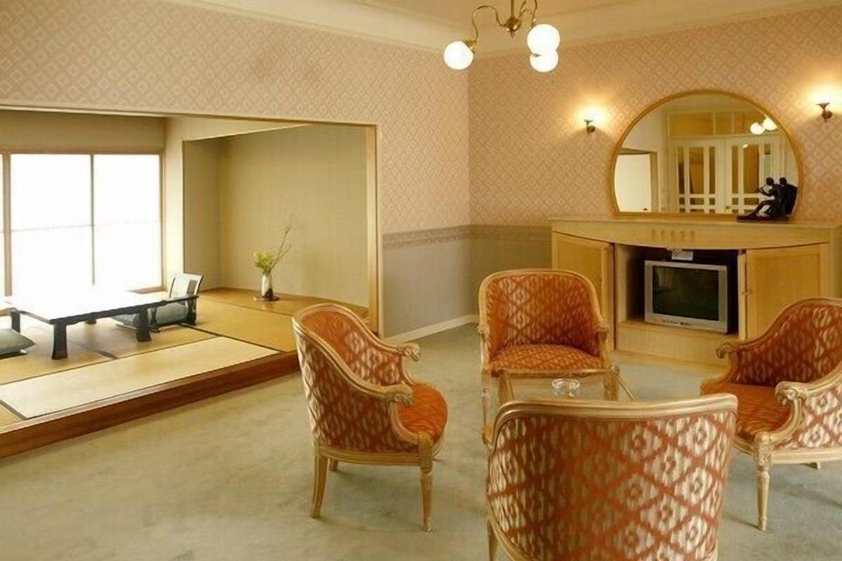 Een traditionele Japanse kamer met tatami vloeren, een lage tafel en vier gestreept stoelen.