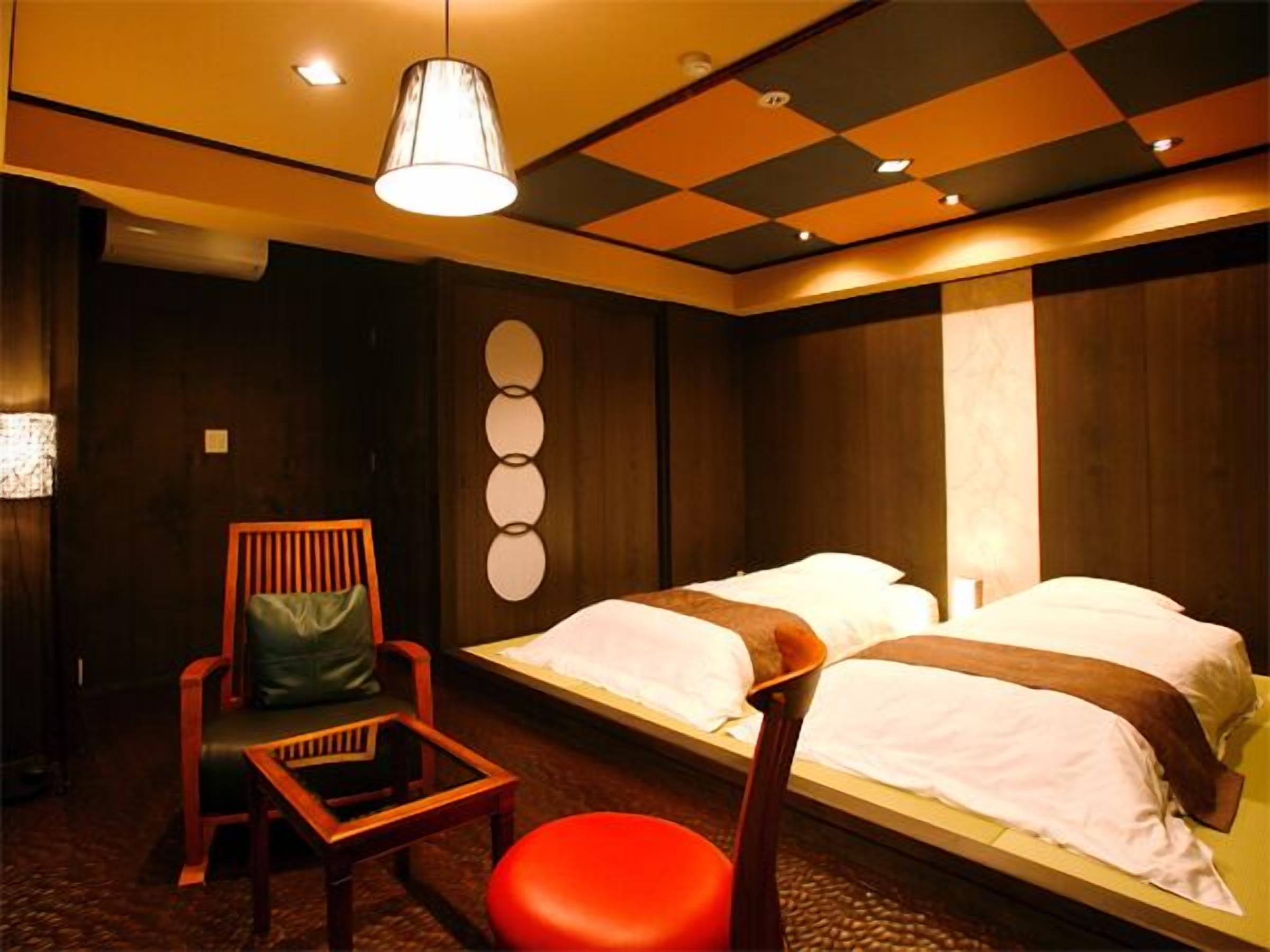 Ein Hotelzimmer mit einem Bett, einem Sessel und einem Tisch.