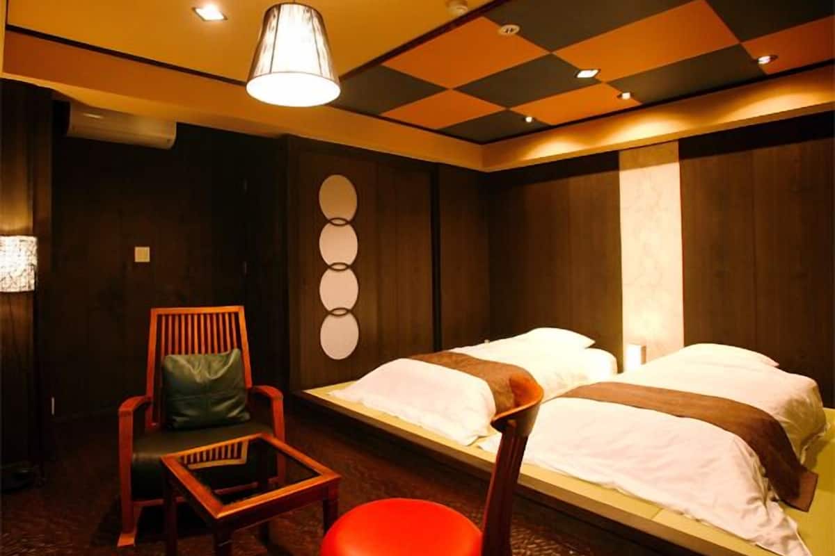 Een hotelkamer met een bed, een stoel en een tafel.