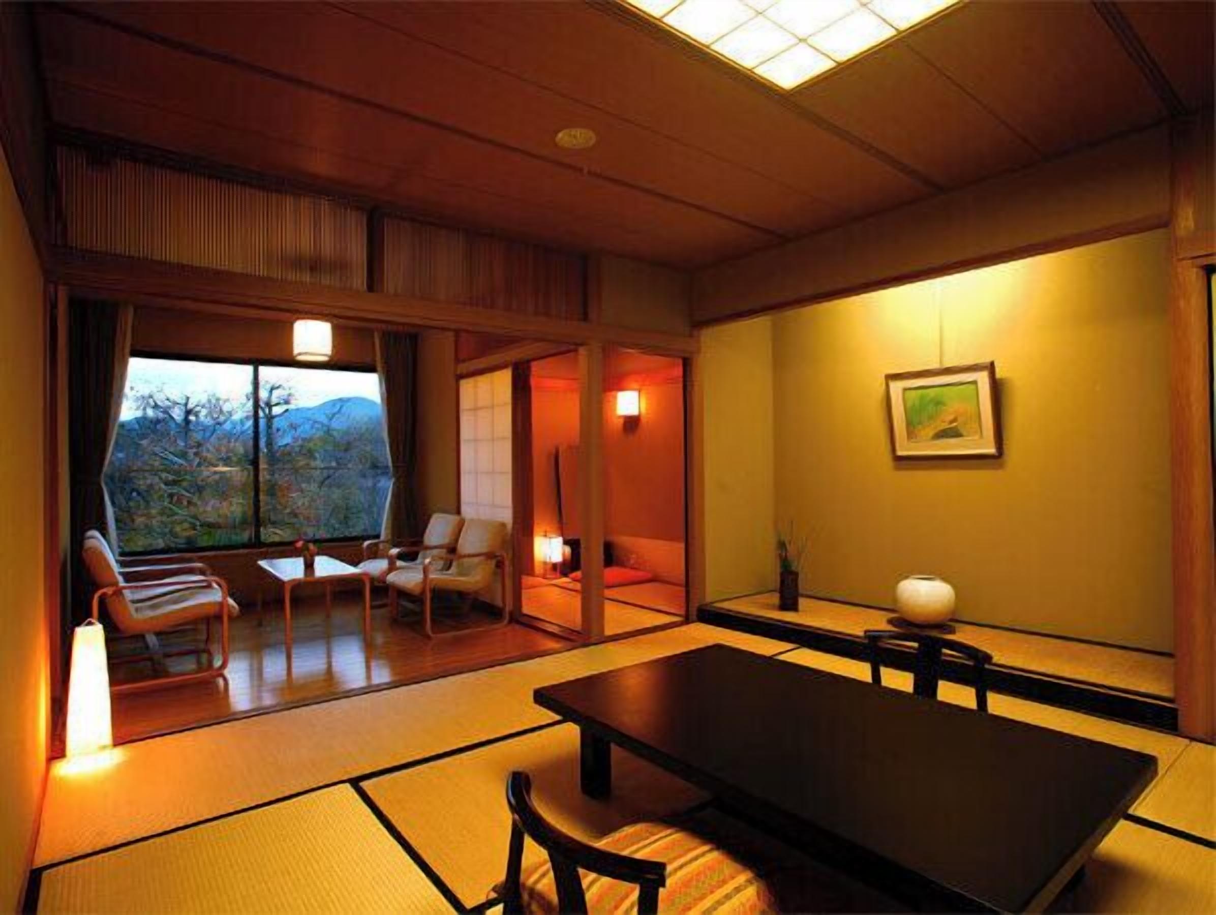 Ein traditioneller japanischer Raum mit Tatami-Böden, einem niedrigen Tisch und Blick ins Freie.