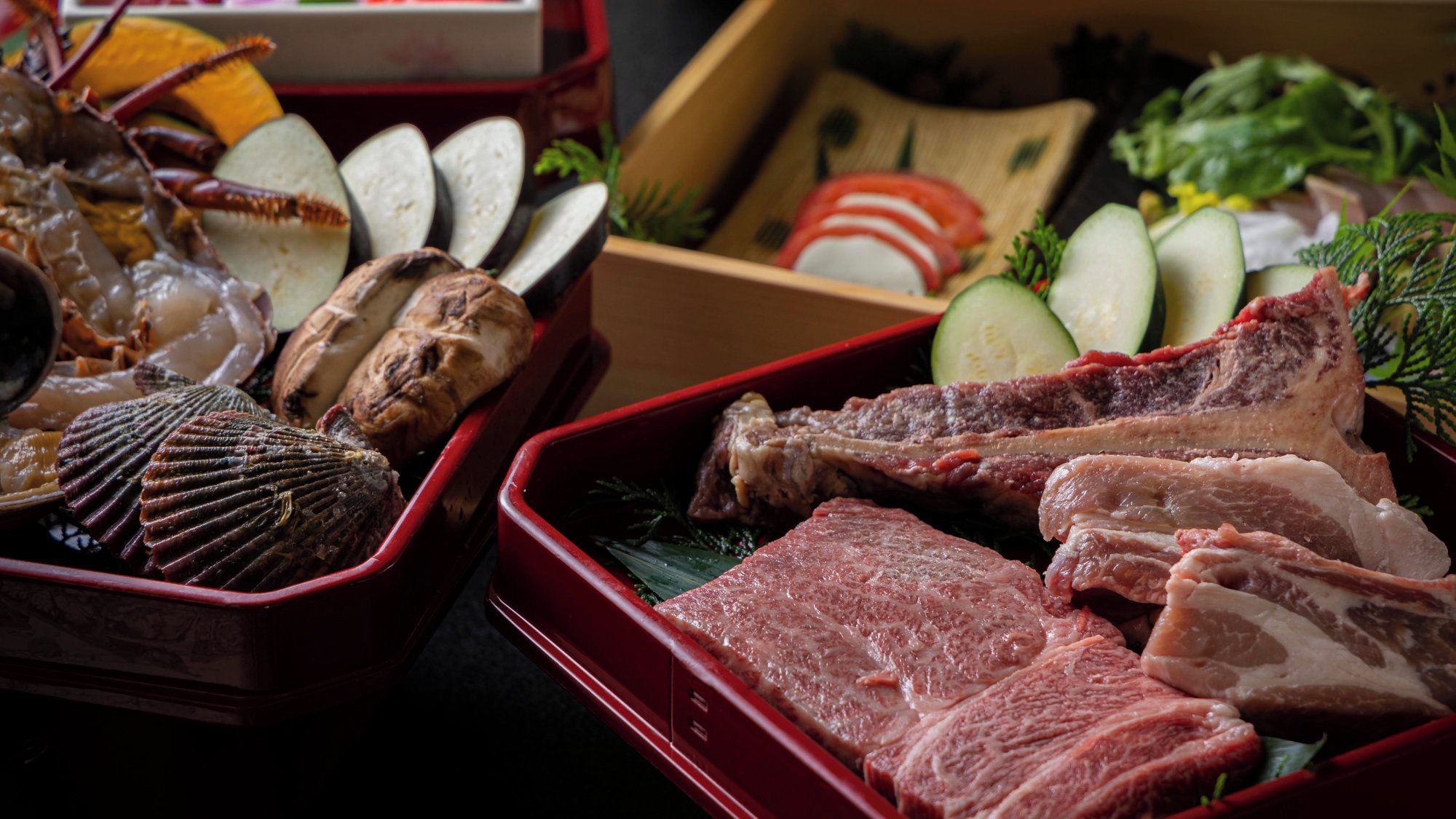 A variety of seafood and meat in red containers, including scallops, crab legs, and pork chops.