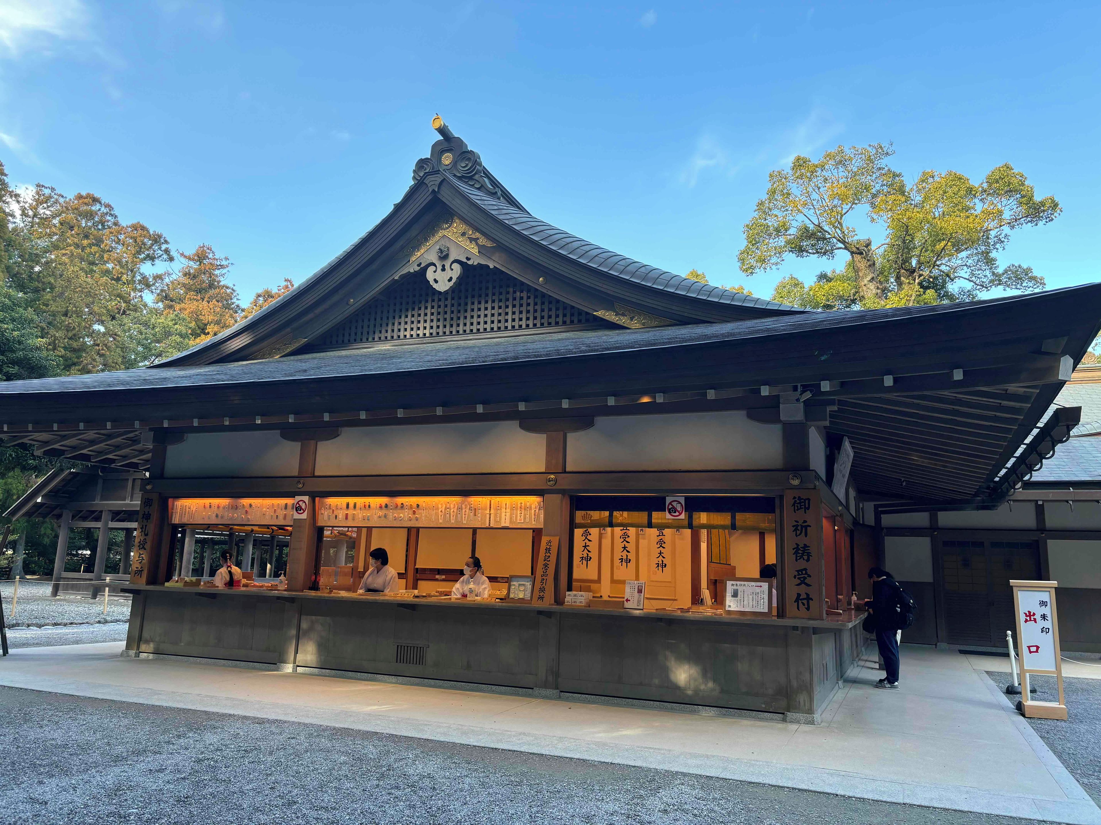 Un edificio japonés tradicional con techo curvo y una mesa de recepción.