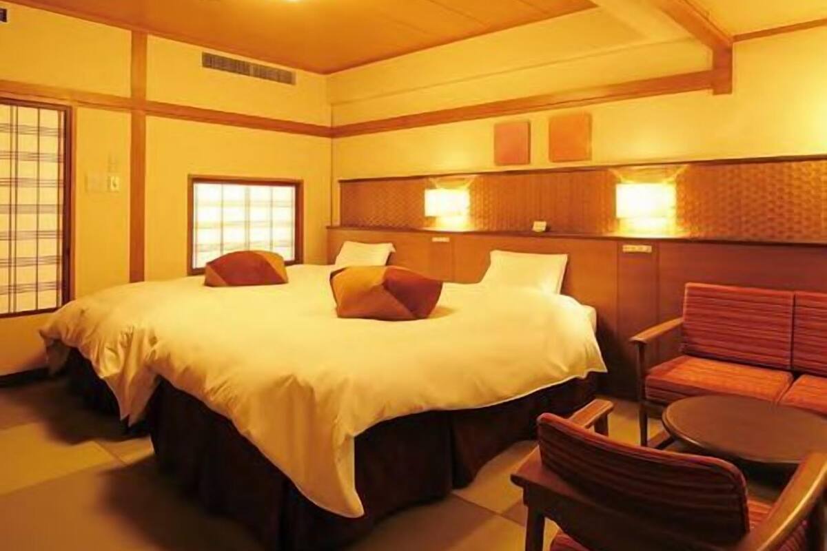 Una habitación de hotel con una cama grande, un sofá y una mesita.