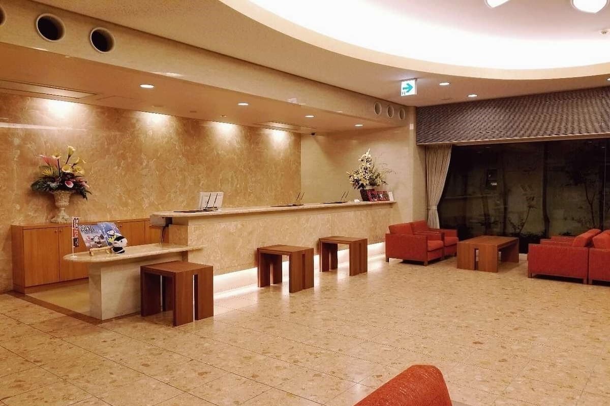 A lobby with a reception desk, seating area, and a large window.