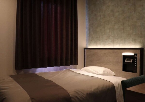 A hotel room with a bed, a headboard with a control panel, and a window with curtains. - Tourist Inn Kochi (Kochi)