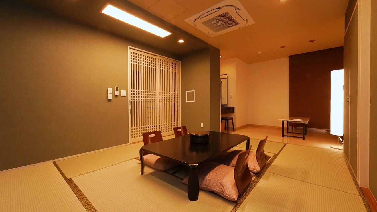 Perinteinen japanilaistyylinen huone, jossa on tatamimatto, matala pöytä ja liukuovi.