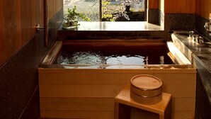 A wooden bathtub with a view of cherry blossoms outside. - Auberge Hanagoyomi (Ito)