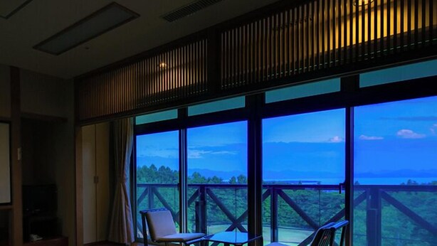 Una habitación con un ventanal amplio, una mesa, dos sillas y vistas al exterior.