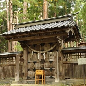 A traditional wooden structure with a tiled roof, a wooden bench, and a fence. - Forest Resort Inawashiro Shiki no Sato (Inawashiro)