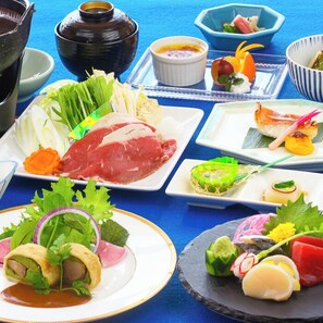 A variety of dishes on a table, including meat, vegetables, and a bowl of soup. - Forest Resort Inawashiro Shiki no Sato (Inawashiro)