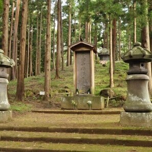 A forested area with a stone monument, steps leading up to it, and stone lanterns. - Forest Resort Inawashiro Shiki no Sato (Inawashiro)