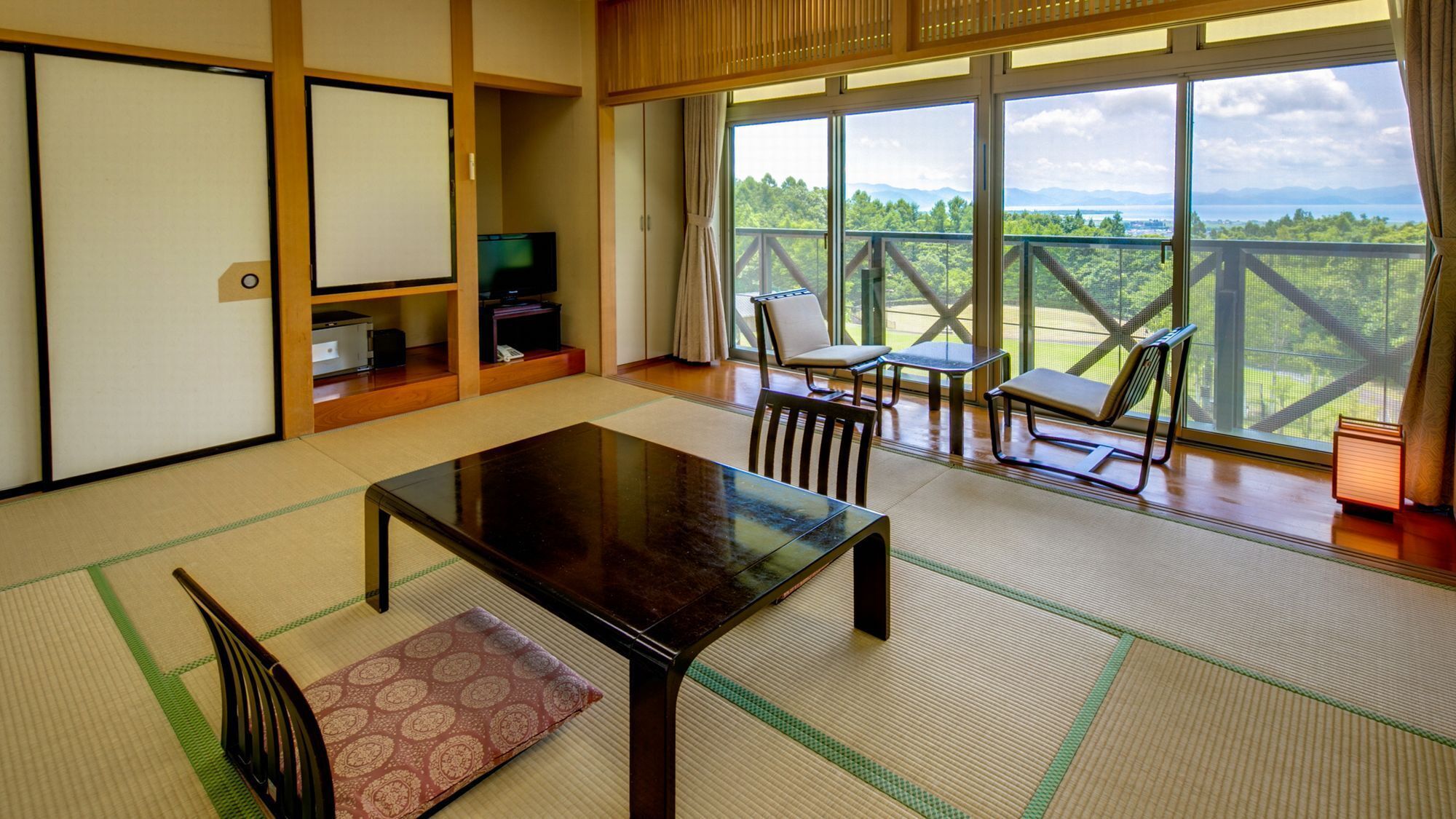 Ein traditioneller japanischer Raum mit Tatami-Böden, einem niedrigen Tisch und Stühlen.
