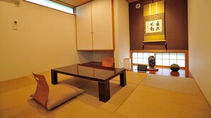 Una tradizionale stanza giapponese con pavimento in tatami, un tavolino basso e porte scorrevoli.