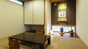 A traditional Japanese room with tatami flooring, a low table, and sliding doors. - Kirishima Yukyu no Yado Isshin (Kirishima)