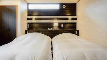 A bedroom with two beds, a skylight, a wooden headboard, and bedside lamps.