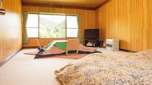 A room with a bed, a futon, a television, and a heater. - Minshuku Yaichi (Gujo)