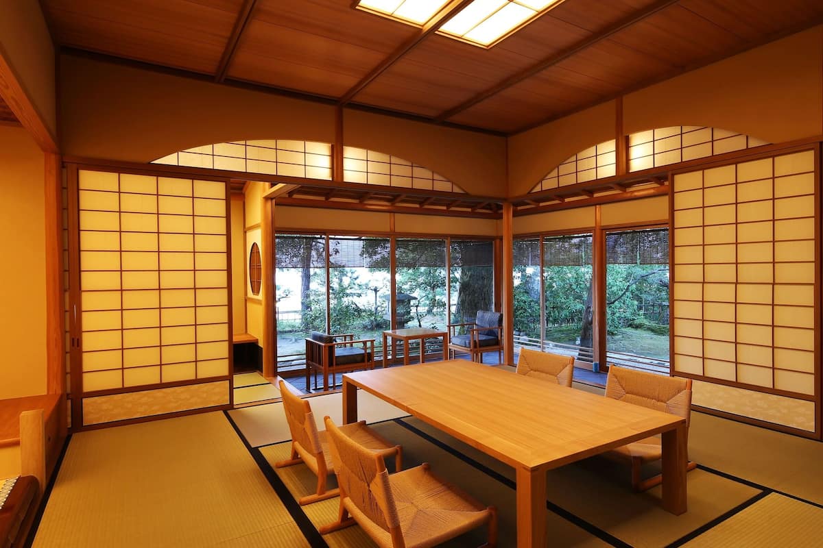 A traditional Japanese room with tatami flooring, a low table, and sliding doors.