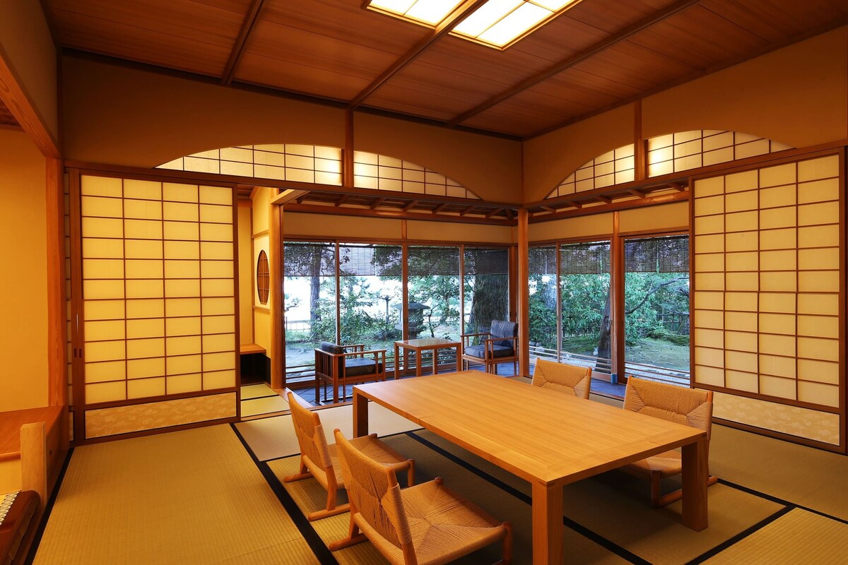 Une pièce de style japonais traditionnel, avec un sol recouvert de tatamis, une table basse et des portes coulissantes.