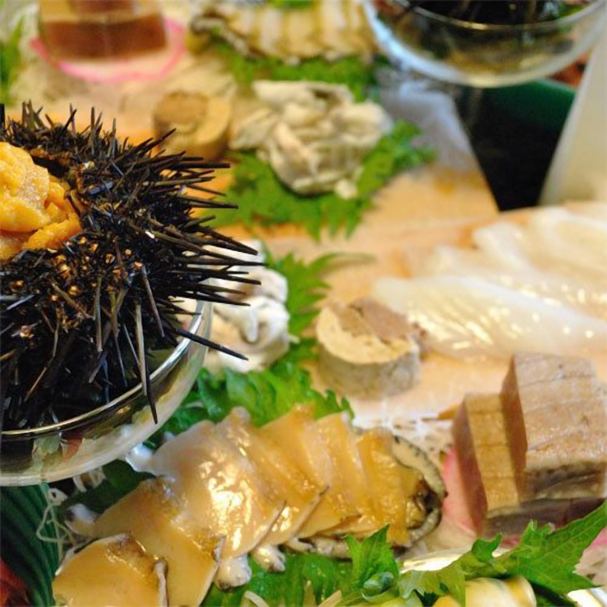 A seafood platter with various types of fish and shellfish, garnished with green leaves.
