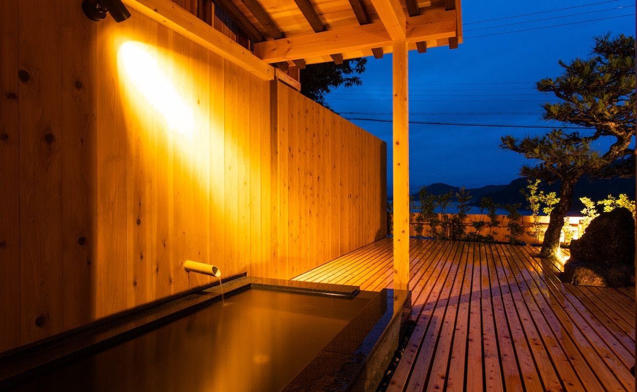 Un espace de bien-être en bois comprenant un jacuzzi et une terrasse en bois.