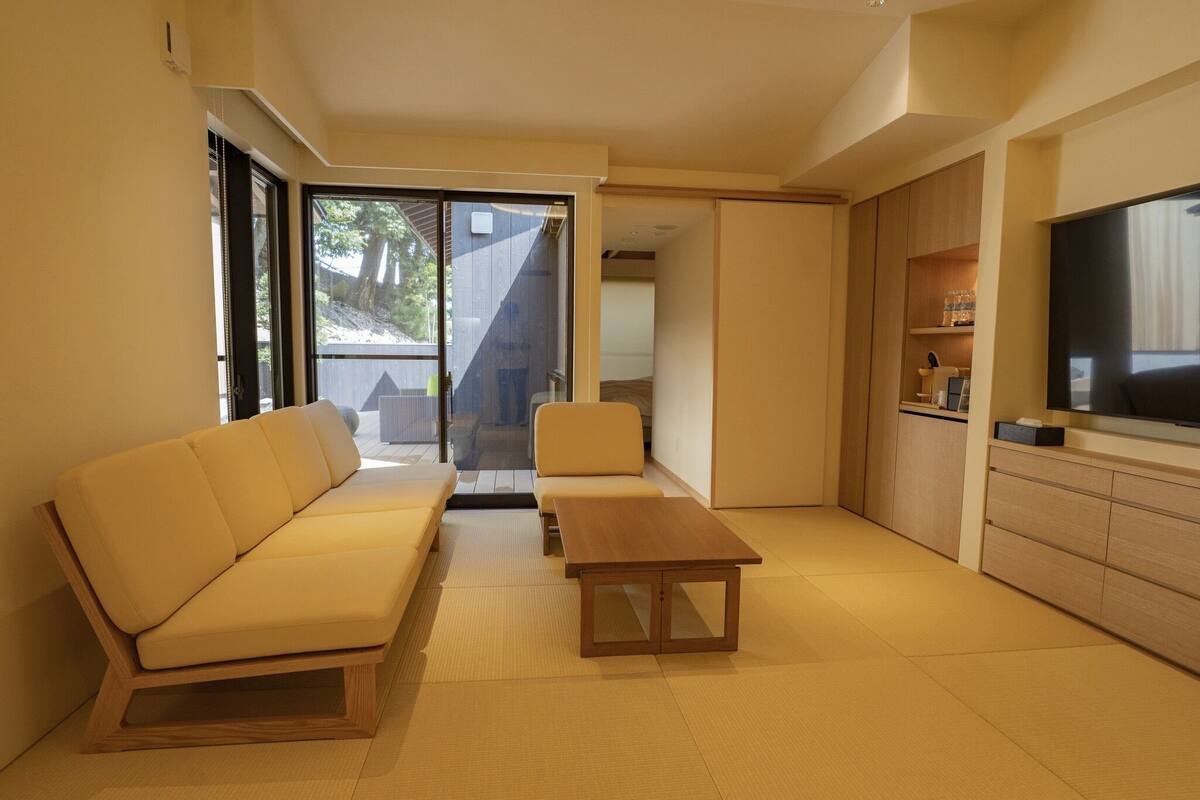 A modern living room with a sofa, a coffee table, and a TV.