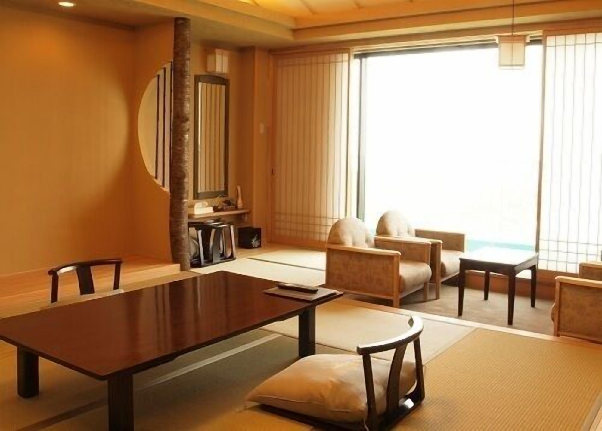 Una habitación tradicional japonesa con esteras de tatami, una mesa baja y asientos.