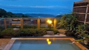 A hot spring area with a wooden deck, a hot tub, and a glass-enclosed viewing area. - Dake Onsen Nagame no Yakata Kounkaku (Nihommatsu)