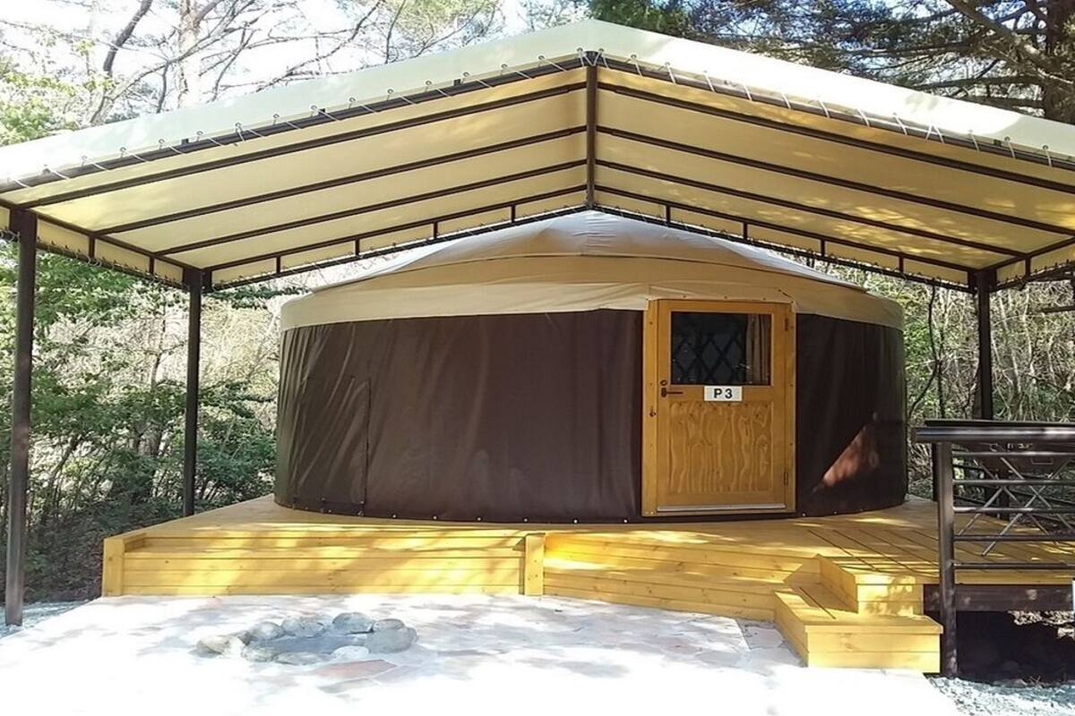 Une structure circulaire couverte, dotée d’une porte en bois portant l’inscription « P3 » et d’une petite plateforme accessible par quelques marches.